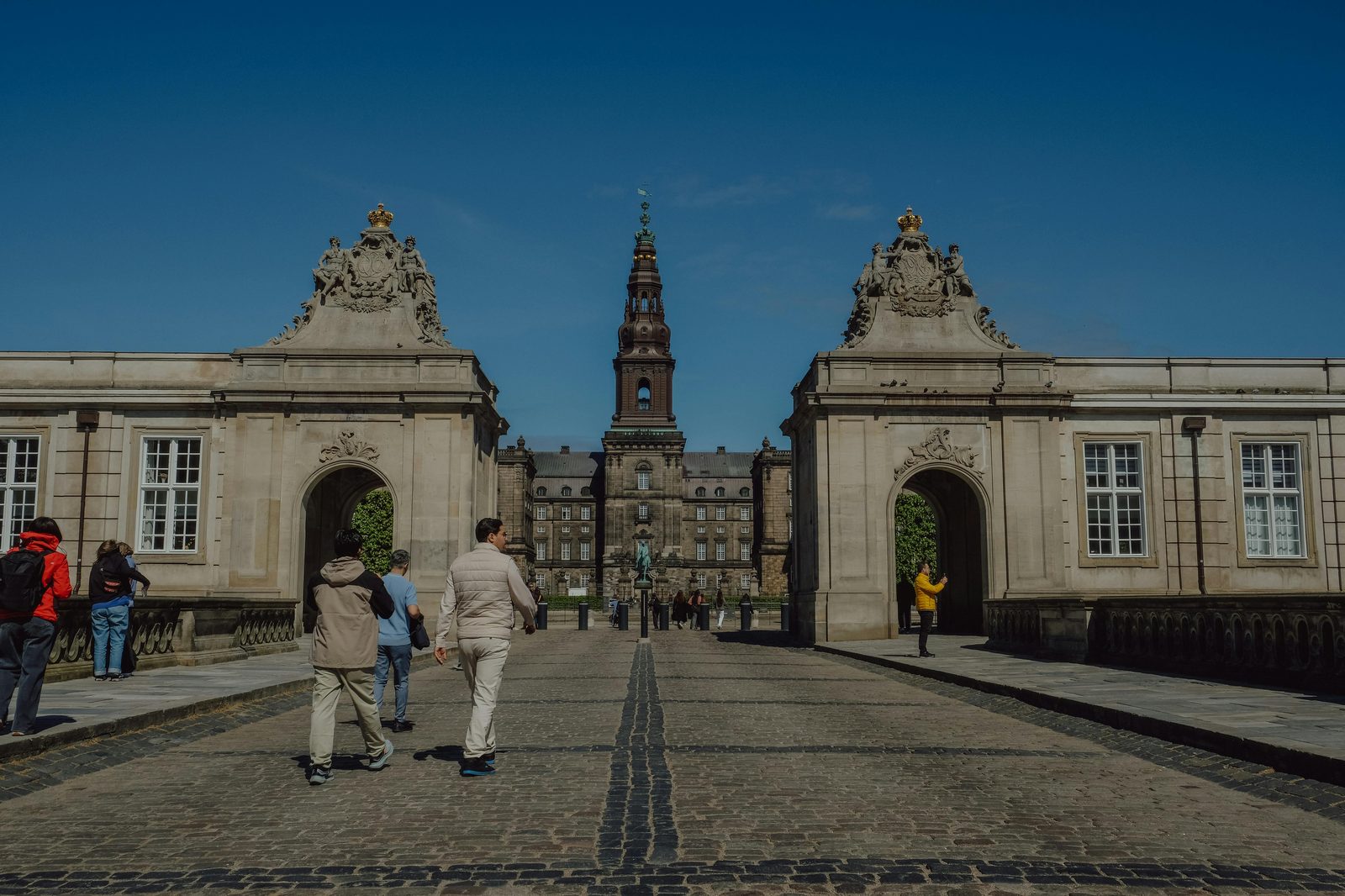 Tourists exploring the historic Christiansborg Palace with grand architecture in Copenhagen — Denmark's seat of government and only building housing all three branches of state