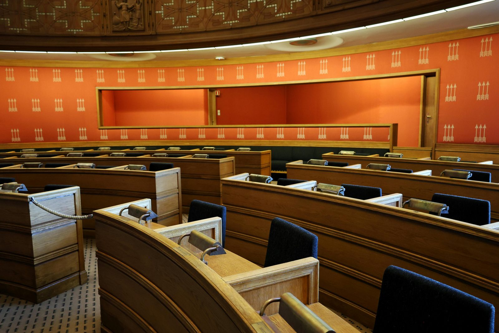 An empty parliamentary meeting room with wooden seating — Folketinget (Danish Parliament) sits in Christiansborg's south wing