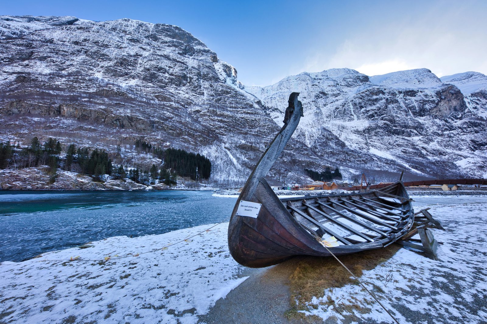 Wooden Viking longship on a Nordic shoreline — similar to the reconstructed Viking ships at Roskilde Viking Ship Museum