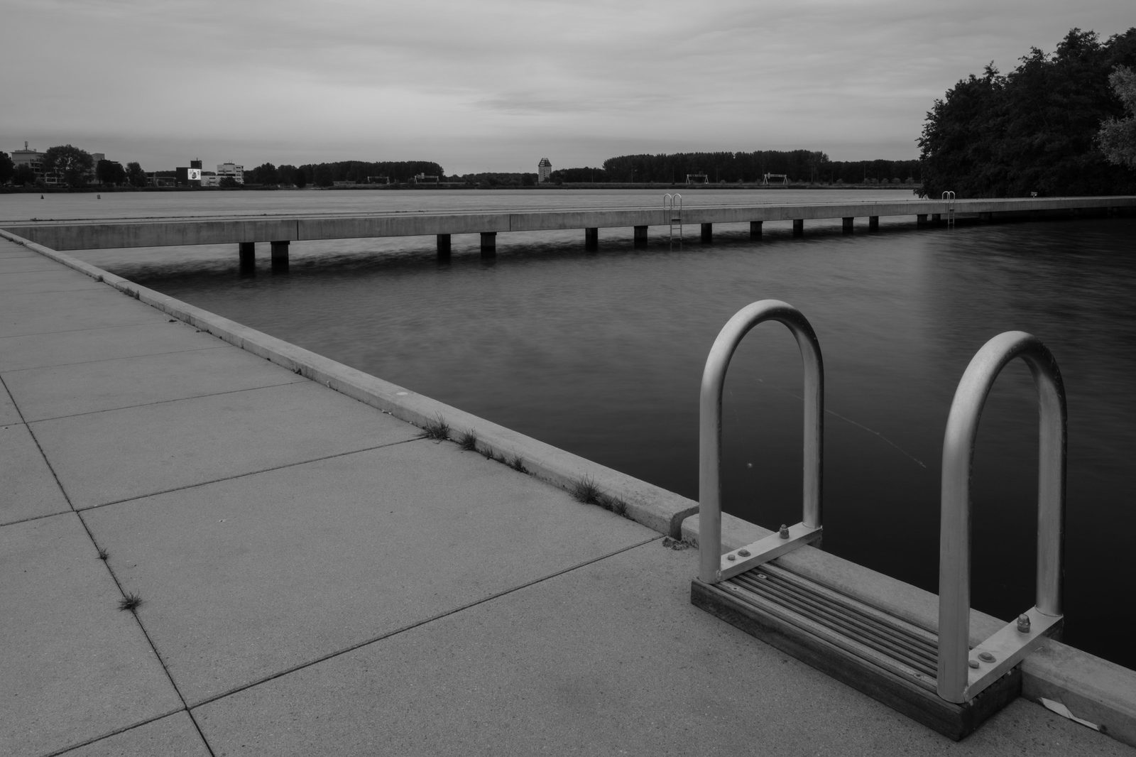 Swimming ladder and concrete pier at an urban harbour — similar to Copenhagen's Islands Brygge Harbour Bath in summer