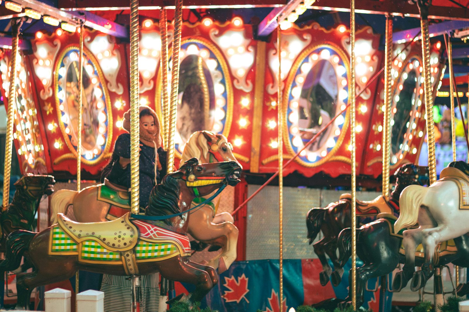 Joyful children riding a brightly illuminated carousel at night — similar to Tivoli Gardens Copenhagen's vintage rides for small children