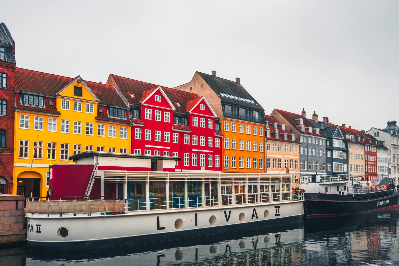 Colorful townhouses and wooden ships line the Nyhavn canal in Copenhagen's Indre By neighborhood