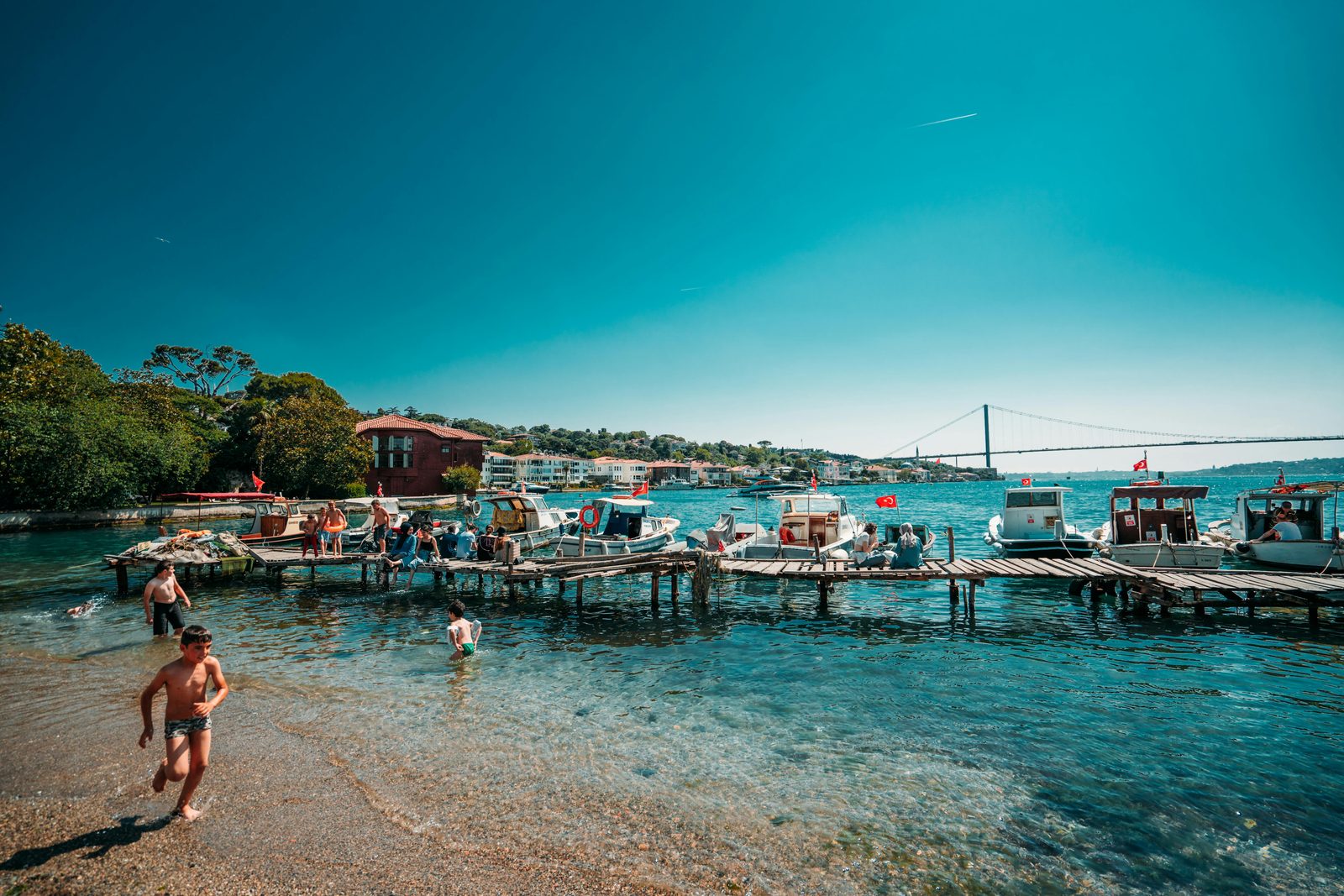 Summer swimmers and boats near a harbour bridge — similar to Copenhagen's Islands Brygge harbour bath in July