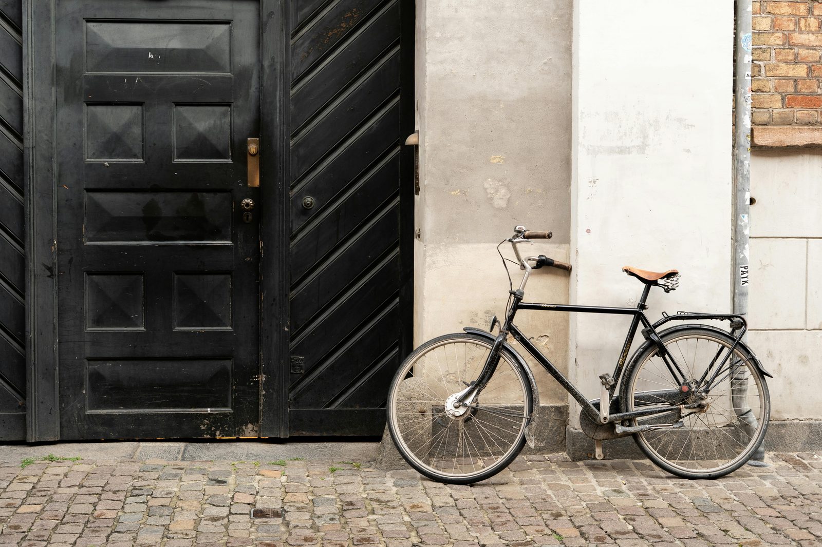 Classic bicycle leaning against a wall in Copenhagen, Denmark — there are five times as many bikes as cars in the city and cycling is the single best travel tip