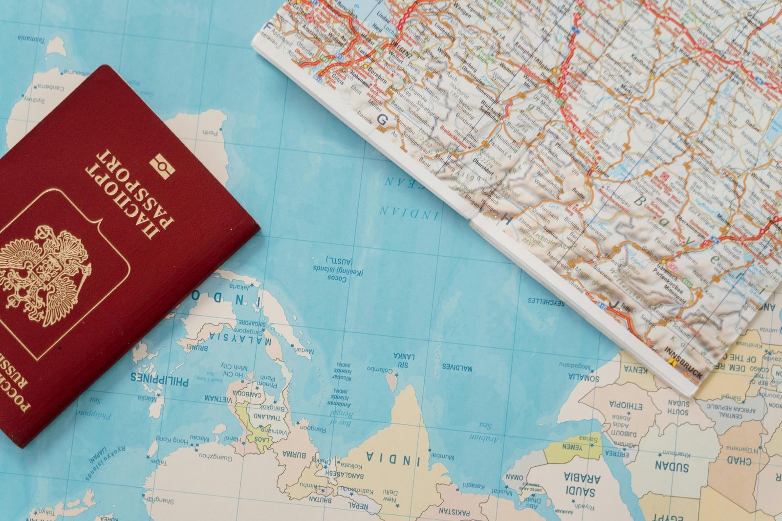 Passport and world map flat lay for trip planning — the paperwork and booking essentials every Copenhagen travel tips guide starts with