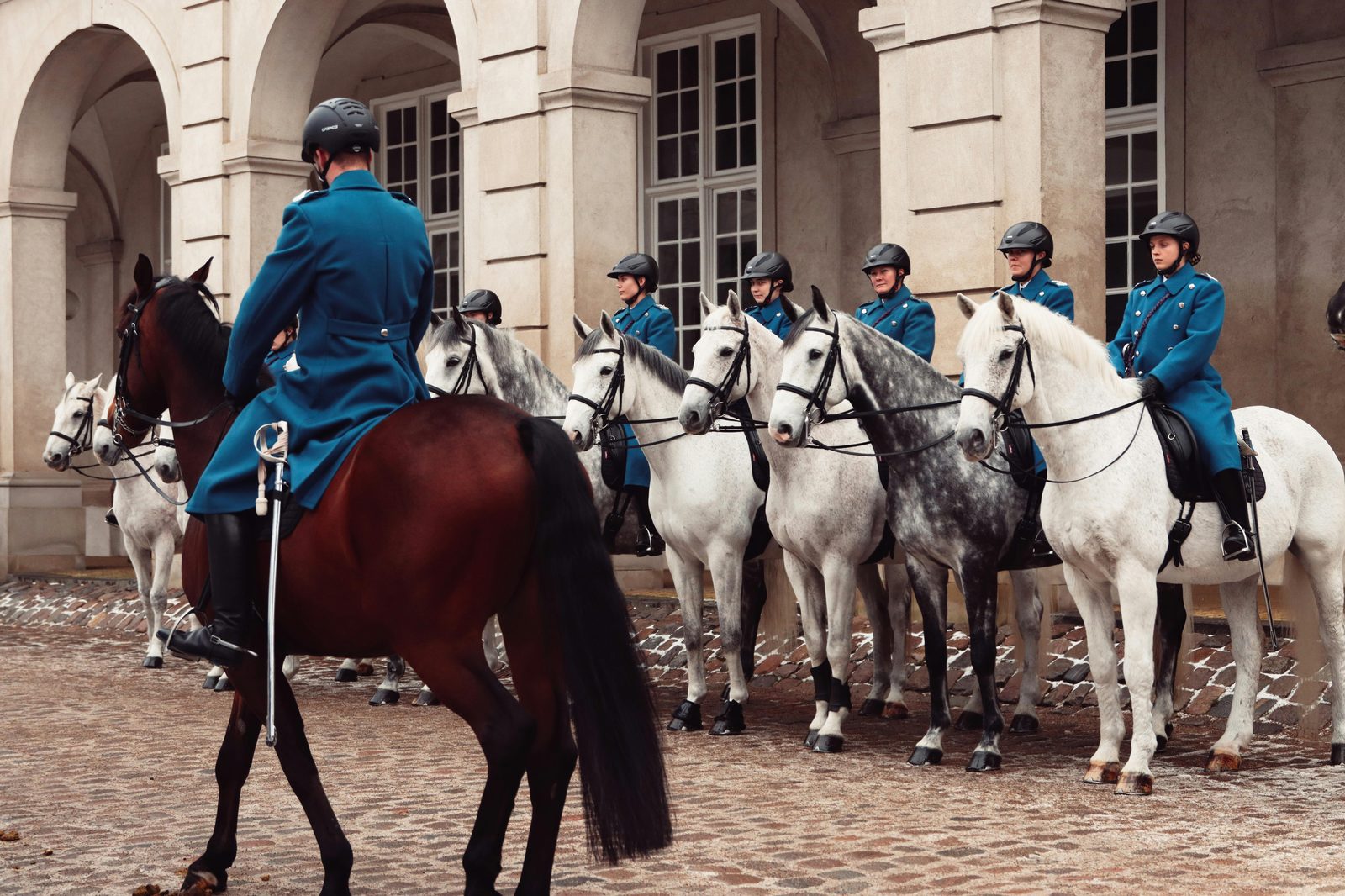 Royal guards on horseback at a historic building in Copenhagen — the Royal Life Guard parades from Amalienborg Palace every day at 11:30, ending at 12:00