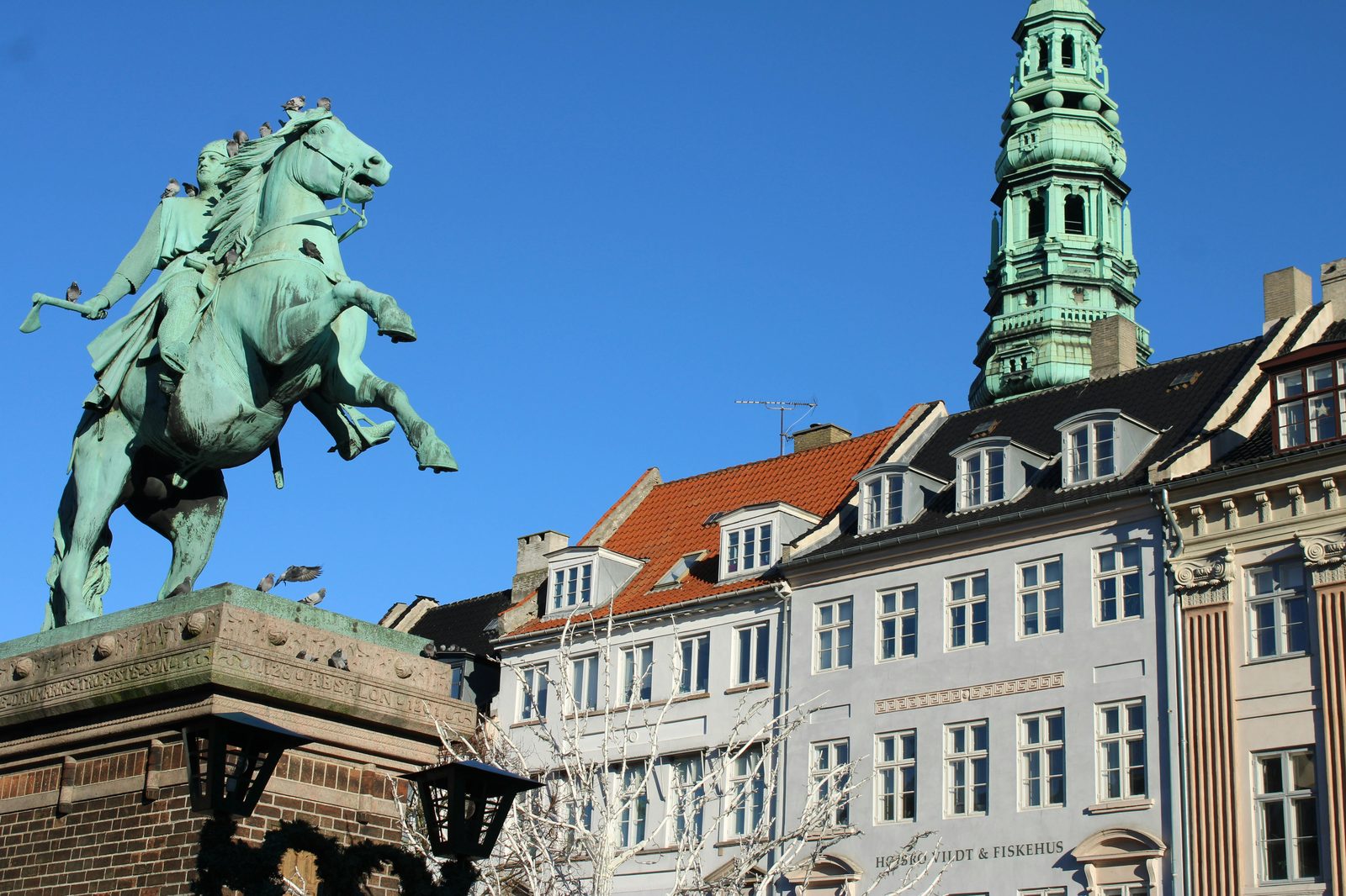 Copenhagen's historical architecture and sculptures under a bright blue sky — the Gefion Fountain sits between Kastellet and the Little Mermaid statue
