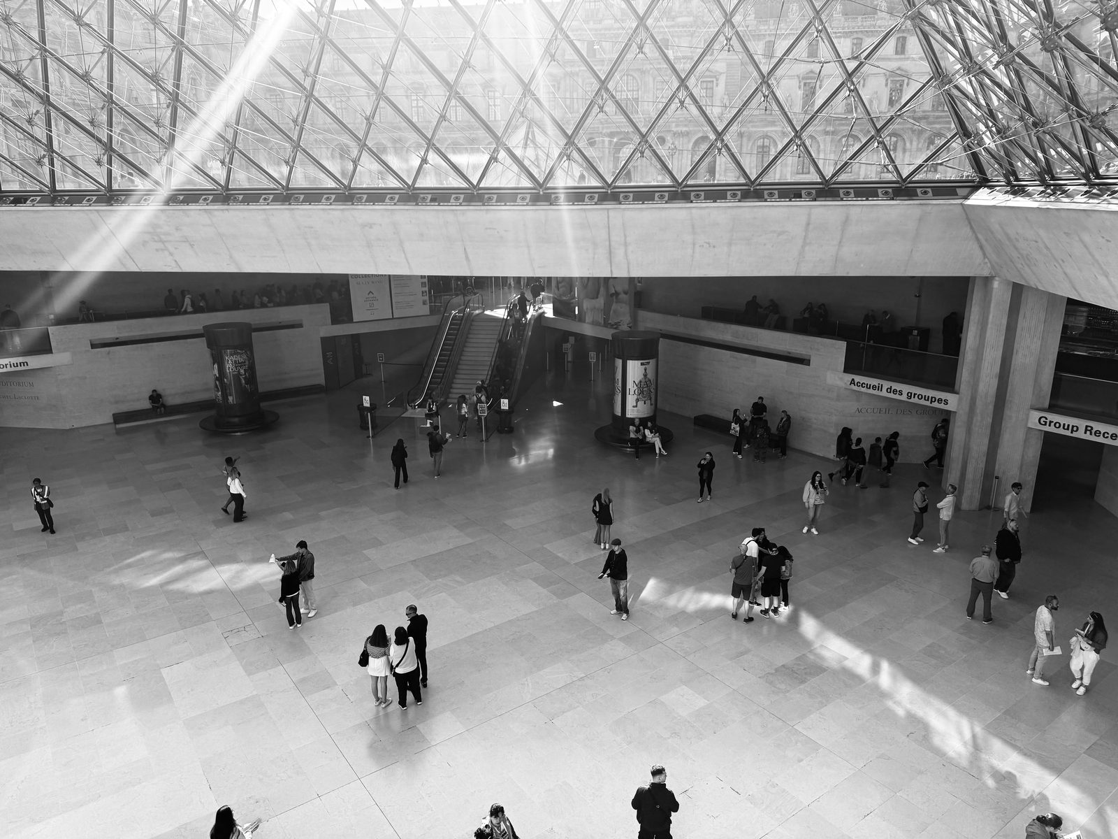 Black and white photo of museum atrium with visitors and sunlight — the National Museum's modern atrium café is a relaxed lunch spot in central Copenhagen