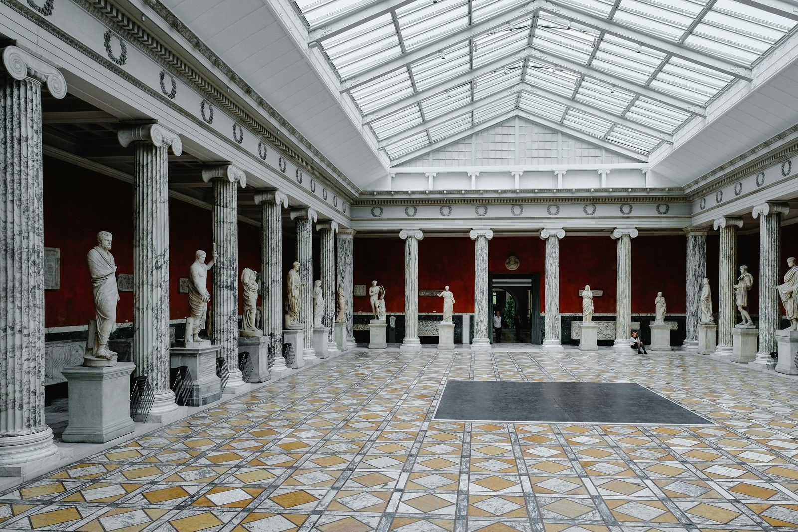 Beautiful classical statues in a historic art museum with ornate columns in Copenhagen — the National Museum of Denmark is the country's largest cultural-history museum, free to visit
