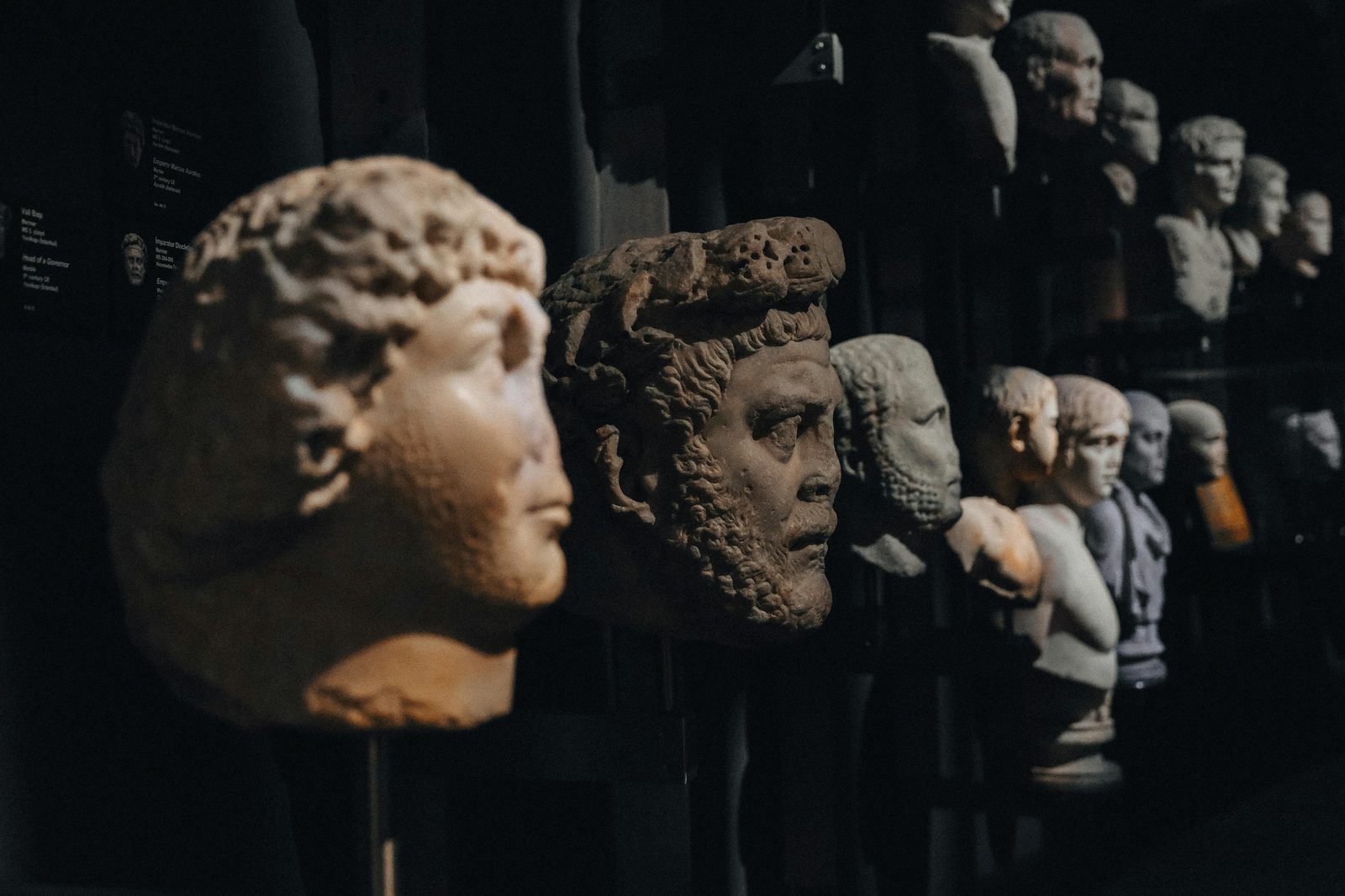 Stone sculptures on display in a dimly lit museum exhibition — the National Museum's prehistoric collection includes the famous Tollund Man and Egtved Girl