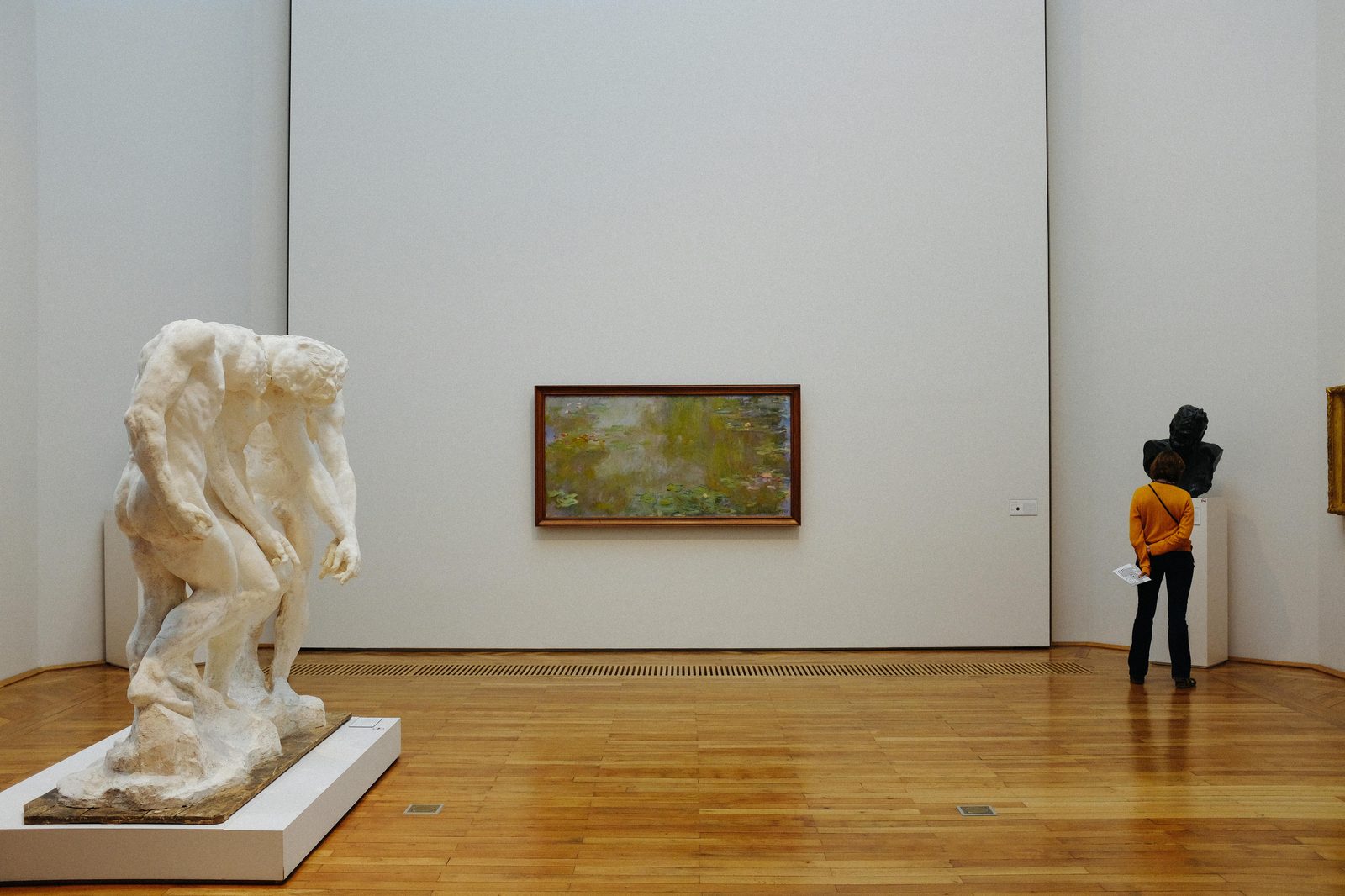 A visitor examines paintings at an art museum — the Glyptotek's French Impressionist collection rivals any in Northern Europe