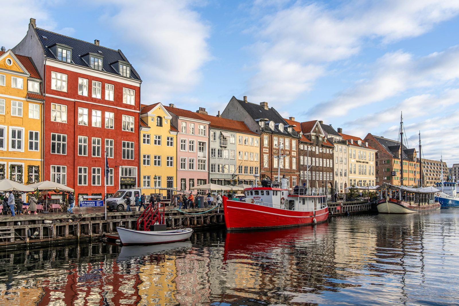 Vibrant Nyhavn waterfront with colorful historic buildings and boats in Copenhagen, seen from above — the canal is 300 metres long and runs from Kongens Nytorv to the Inner Harbour