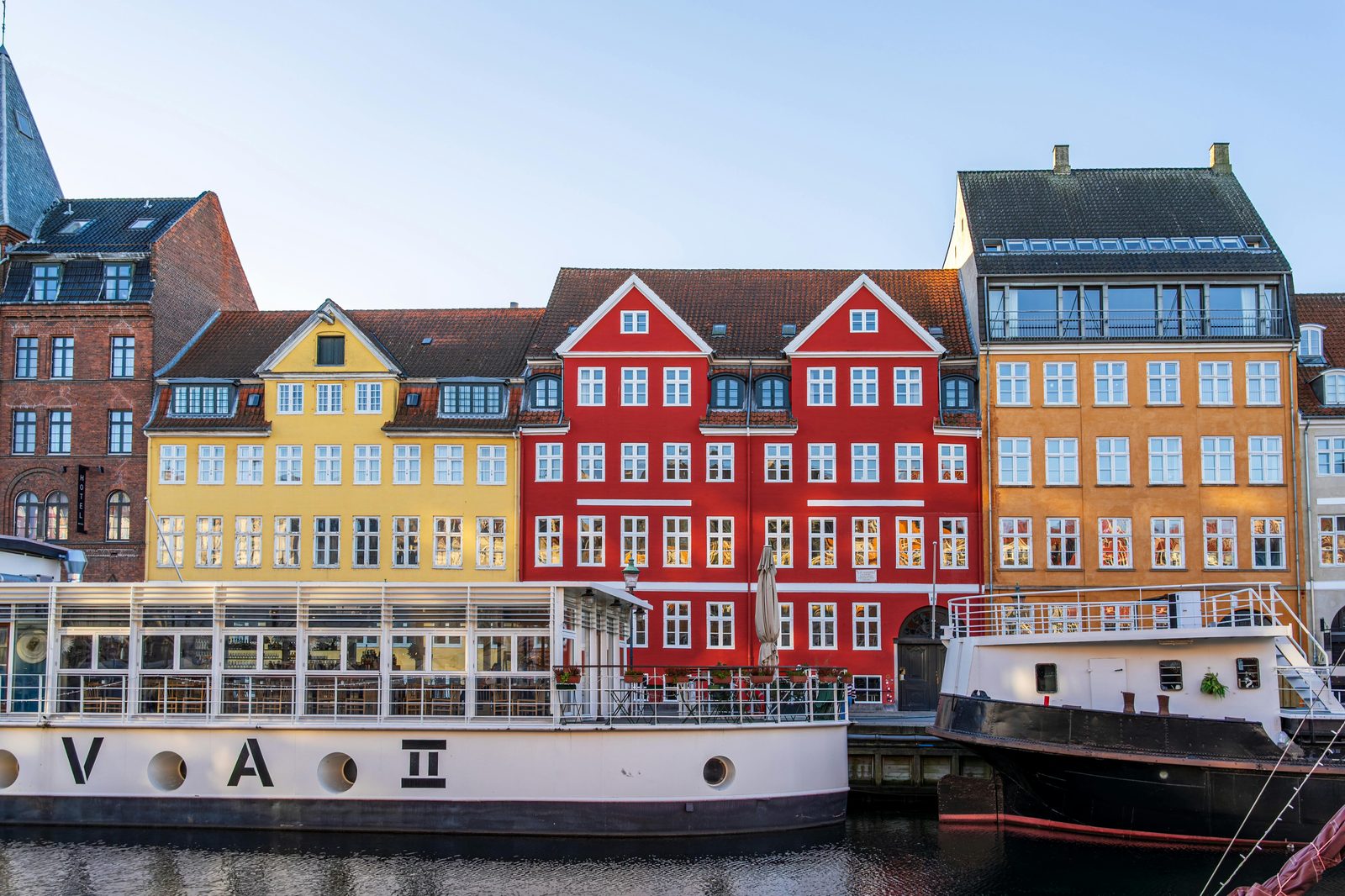 Vibrant historic buildings along Nyhavn canal with boats in Copenhagen, Denmark — Hans Christian Andersen lived in Nyhavn for almost 20 years at numbers 18, 20, and 67