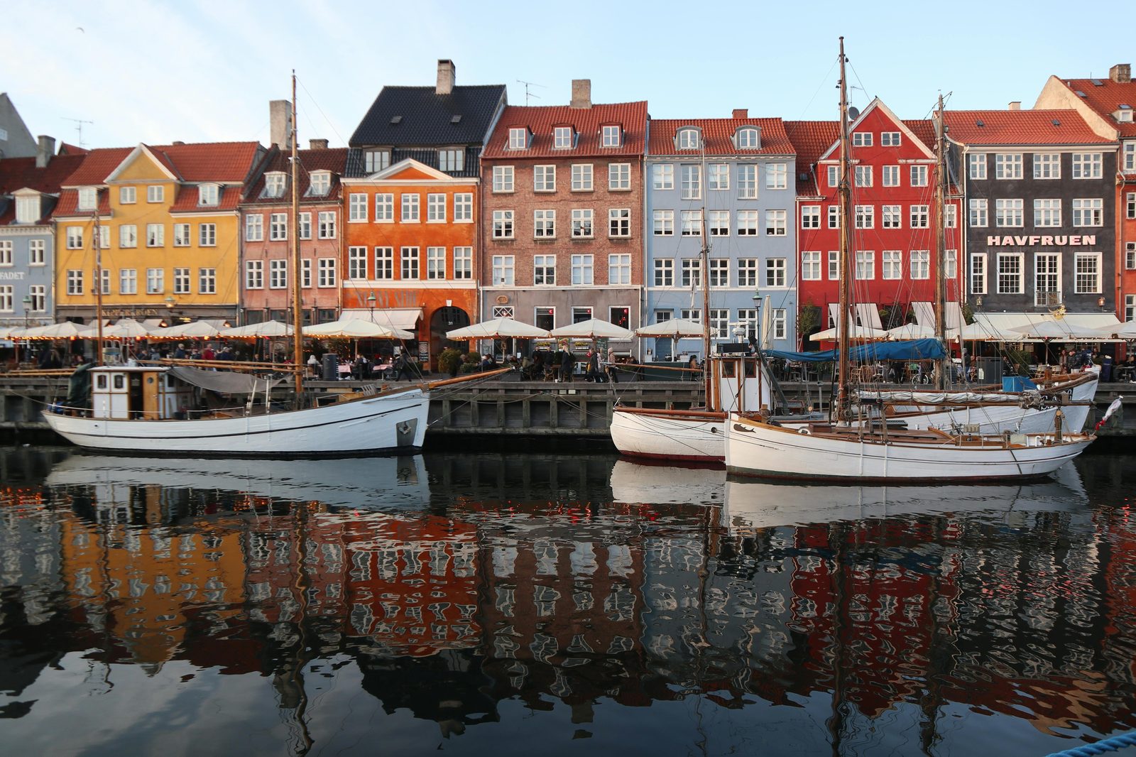 Vibrant townhouses and historic wooden boats moored along the canal — Nyhavn's northern quay is home to vintage Danish wooden sailing vessels