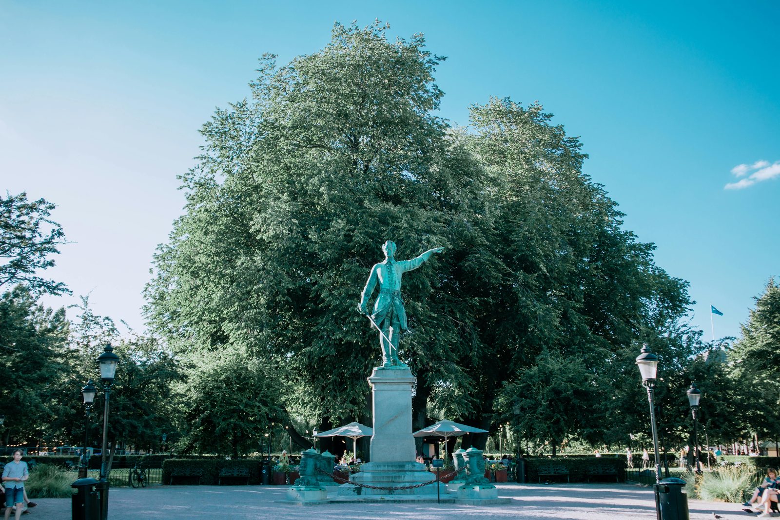 Sunlit park with a statue surrounded by lush greenery — Kongens Have features statues of Hans Christian Andersen, Christian IV and Soldier of 1864