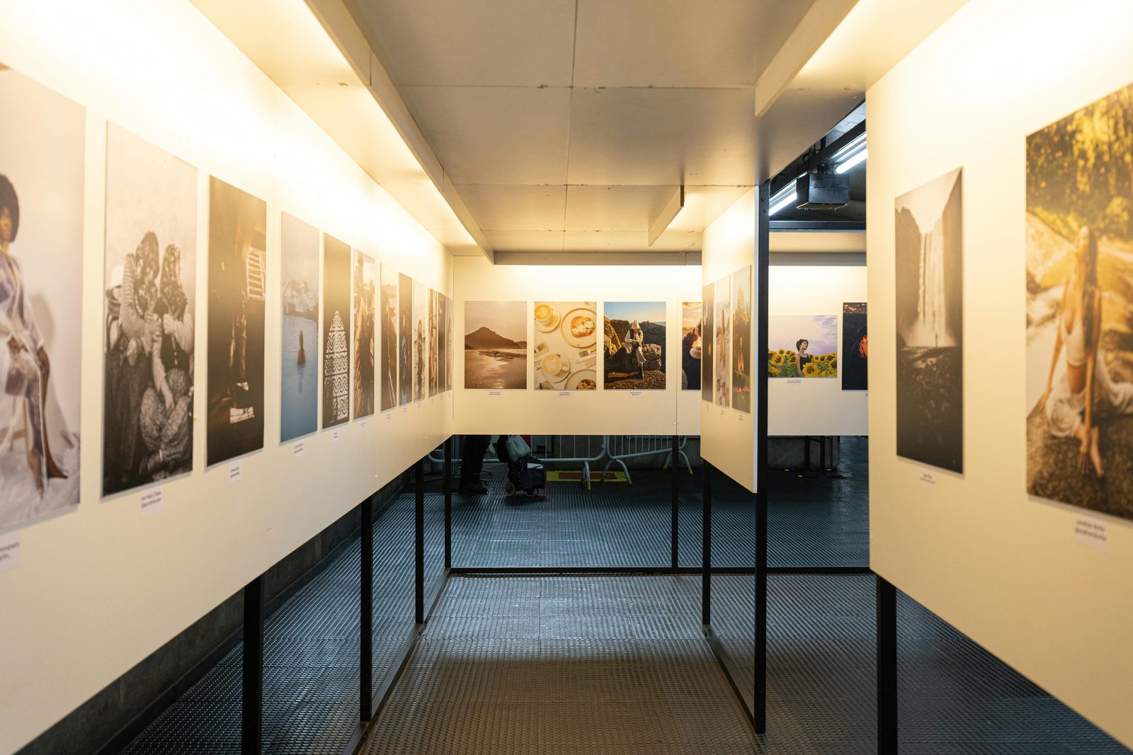 A well-lit art exhibition featuring diverse photographic prints in a modern indoor gallery — Rundetaarn's Library Hall hosts rotating contemporary art exhibitions year-round