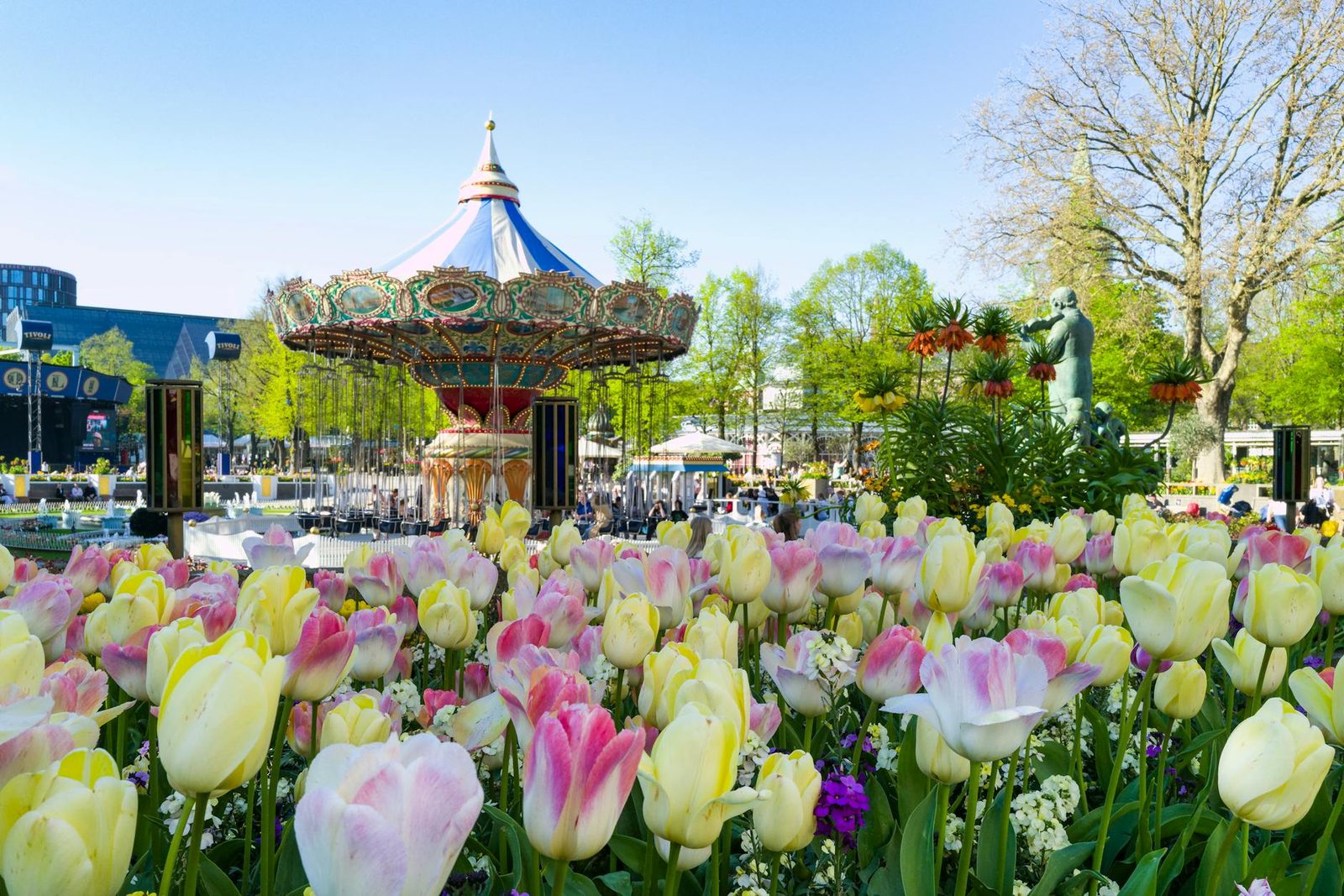 Tivoli Gardens amusement park in Copenhagen at dusk with illuminated rides and lanterns