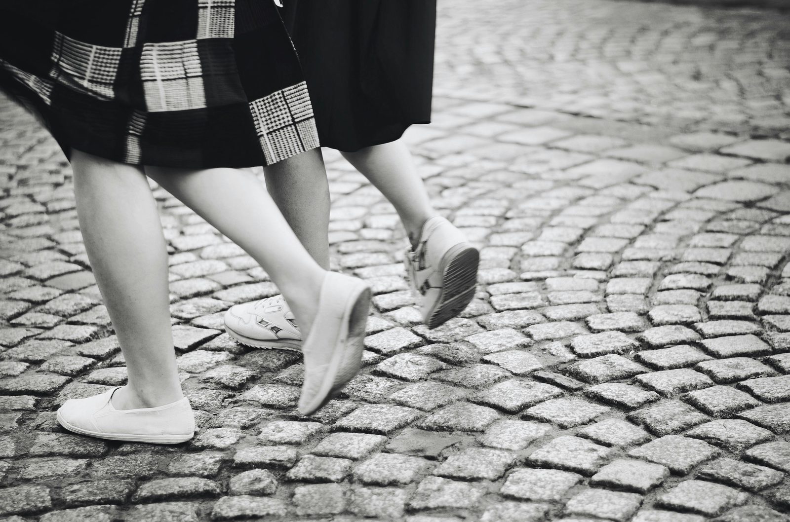 Feet walking on a Copenhagen cobblestone street — tours cover 5-7 km, so comfortable shoes matter