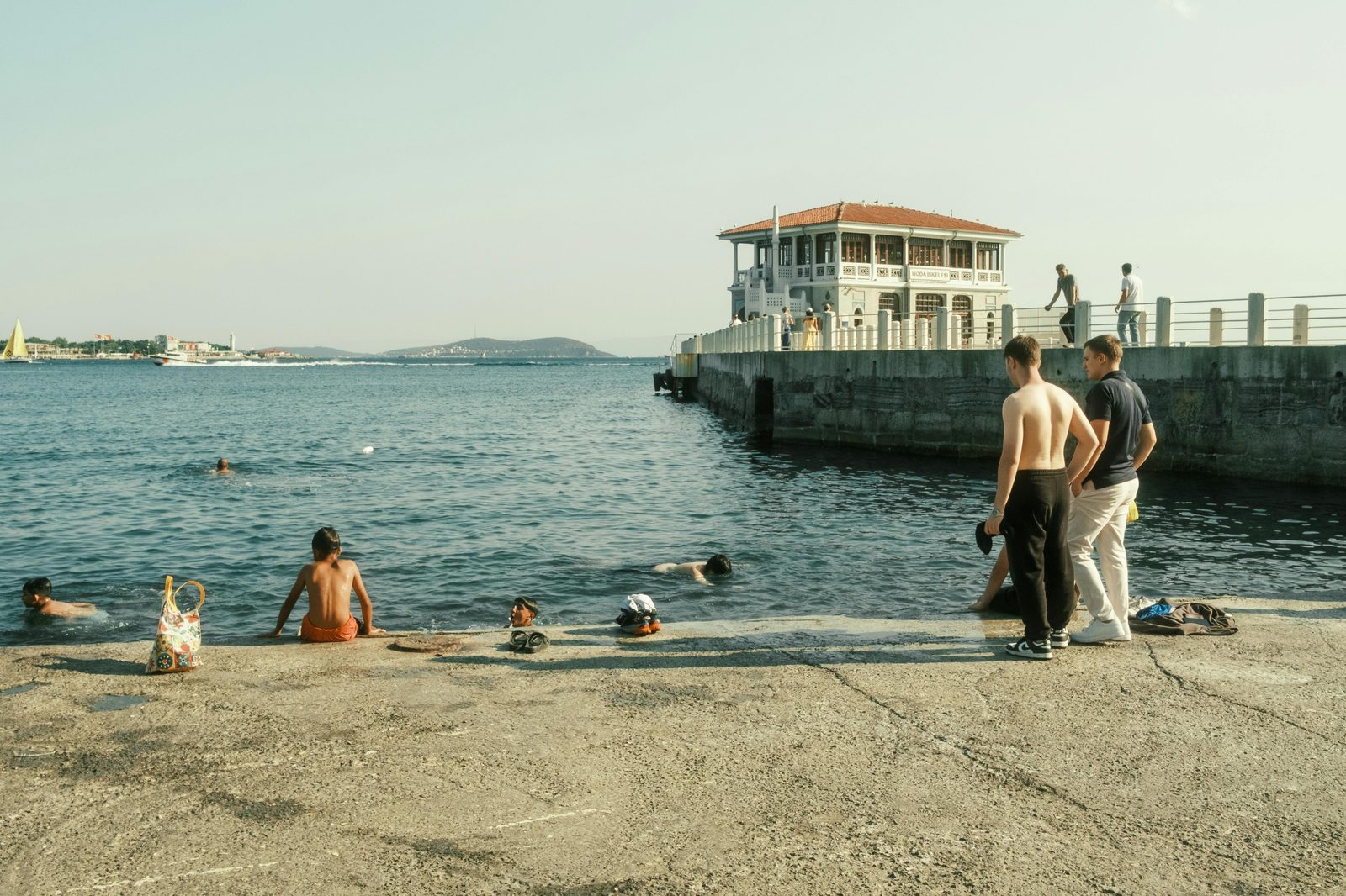 People swim harbor sunny — Copenhagen July harbor swimming at peak with Islands Brygge, Sluseholmen, La Banchina at full capacity
