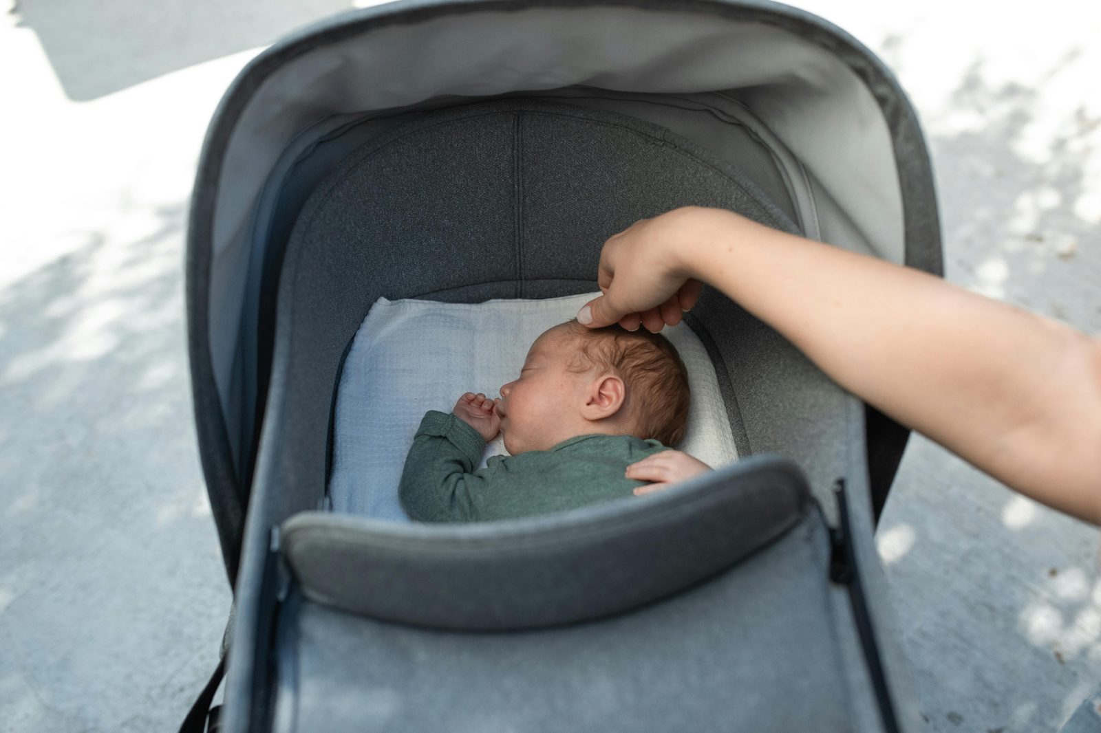 A classic Danish pram left outside a cafe with a napping baby