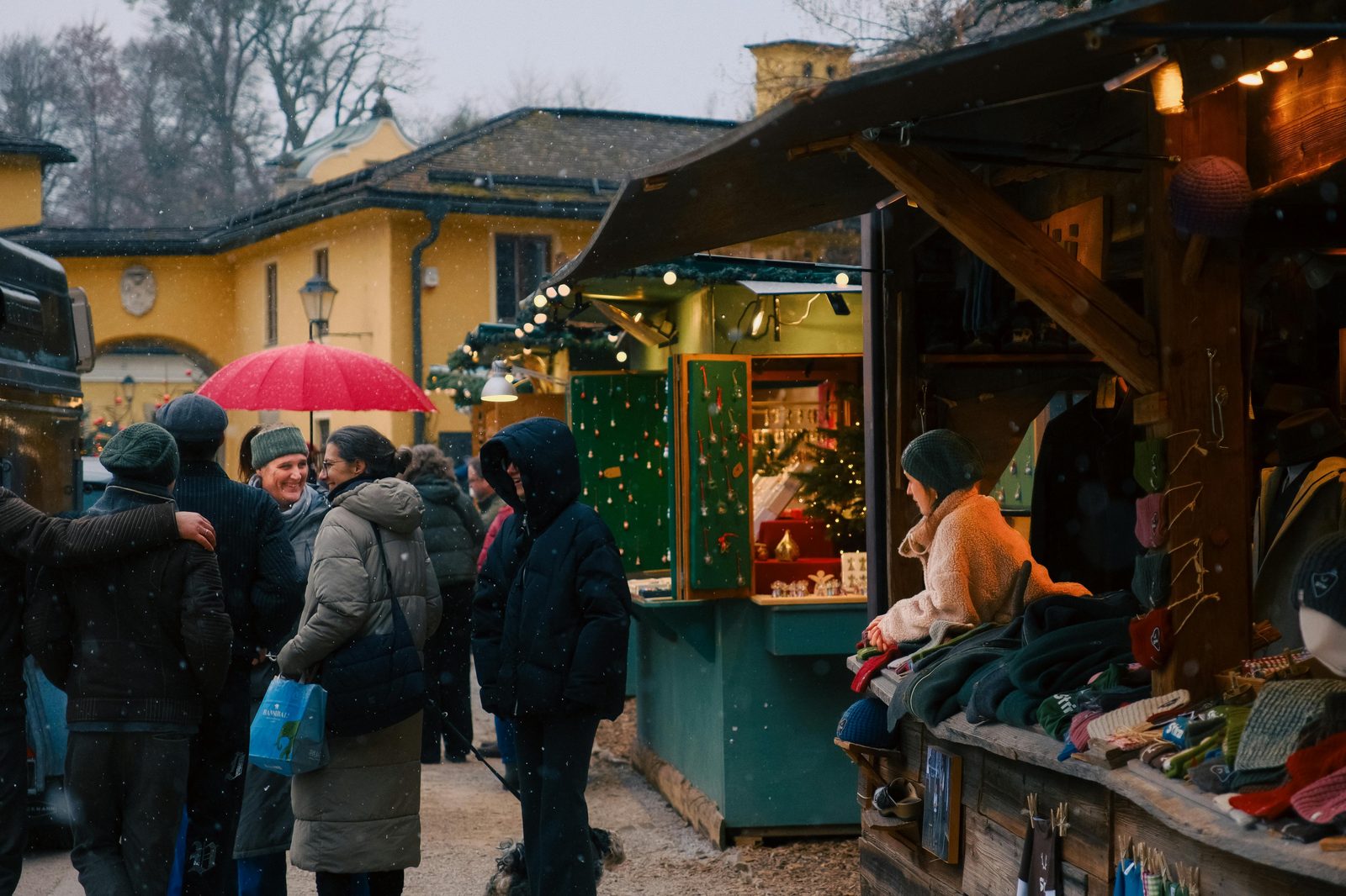 Wooden Christmas stalls under snow at the Tivoli Christmas Market in Copenhagen