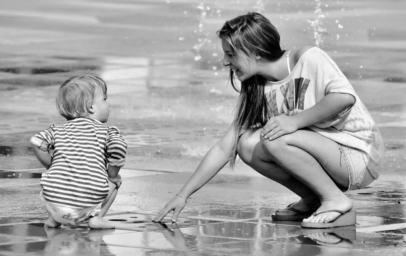 A toddler splashing at the Faelledparken water playground in Copenhagen