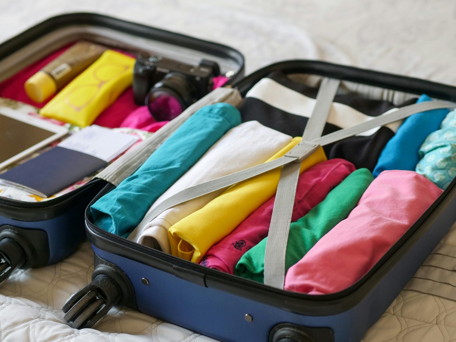 Open suitcase clothes packed travel — Copenhagen packing requires layered approach, waterproof footwear, and weather-flexible items year-round