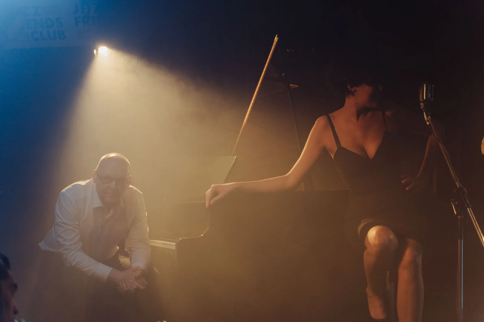 A pianist and singer performing in a small, dimly lit jazz club