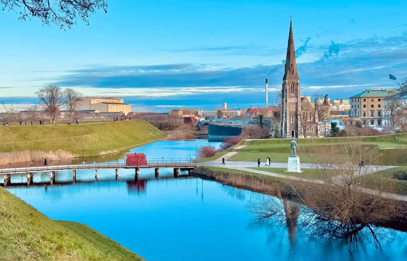 The moat and ramparts of Kastellet with St Alban's Church spire under a clear spring sky in Copenhagen