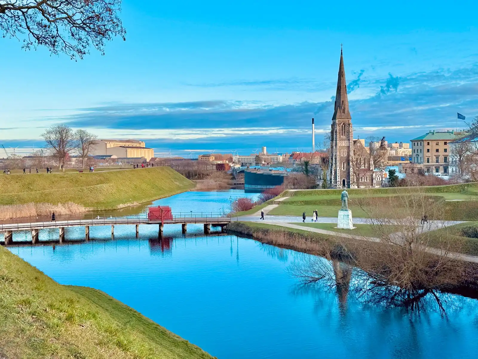 The moat and ramparts of Kastellet with St Alban's Church spire under a clear spring sky in Copenhagen
