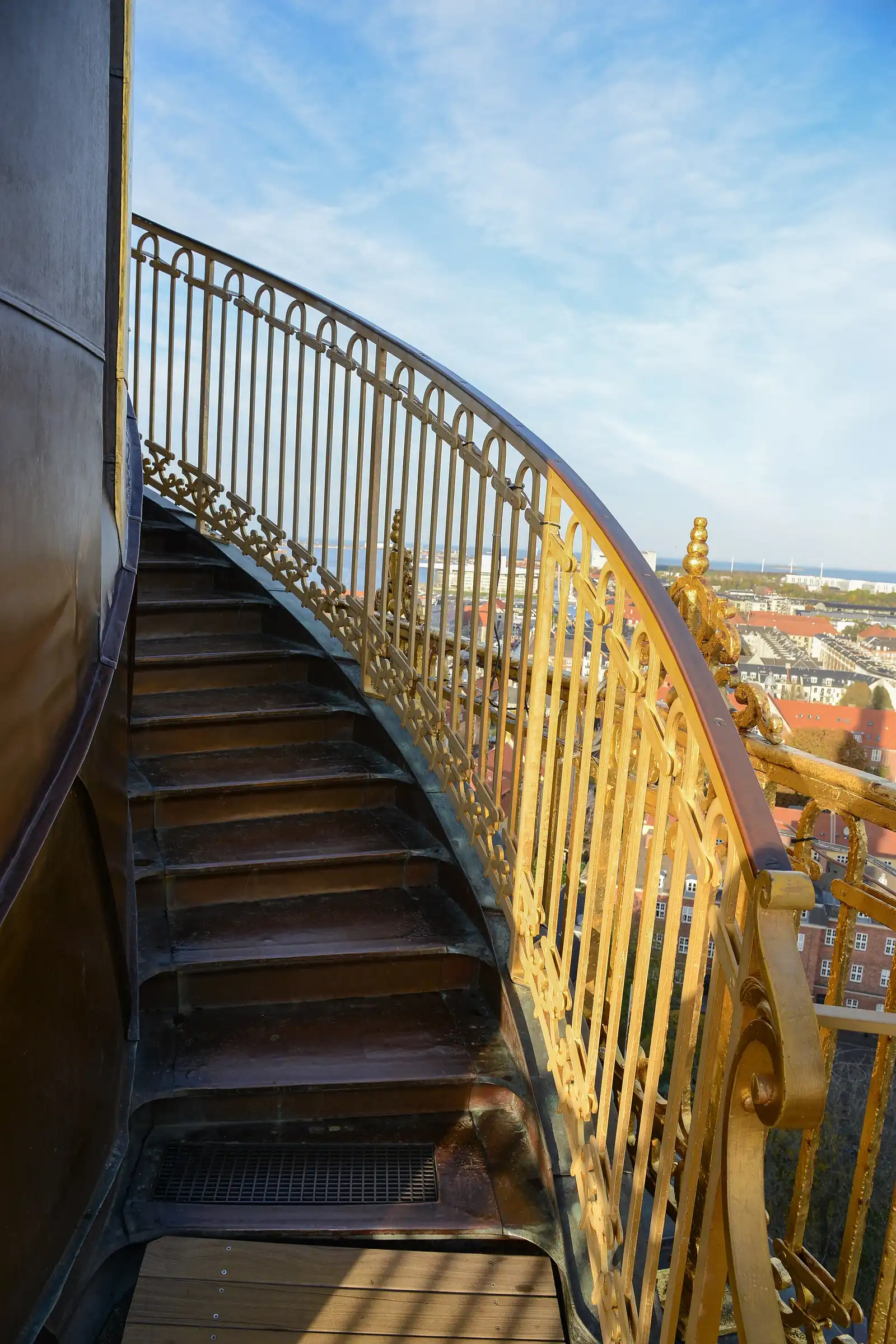 The external copper steps and gilded handrail spiralling around the spire, with Copenhagen below