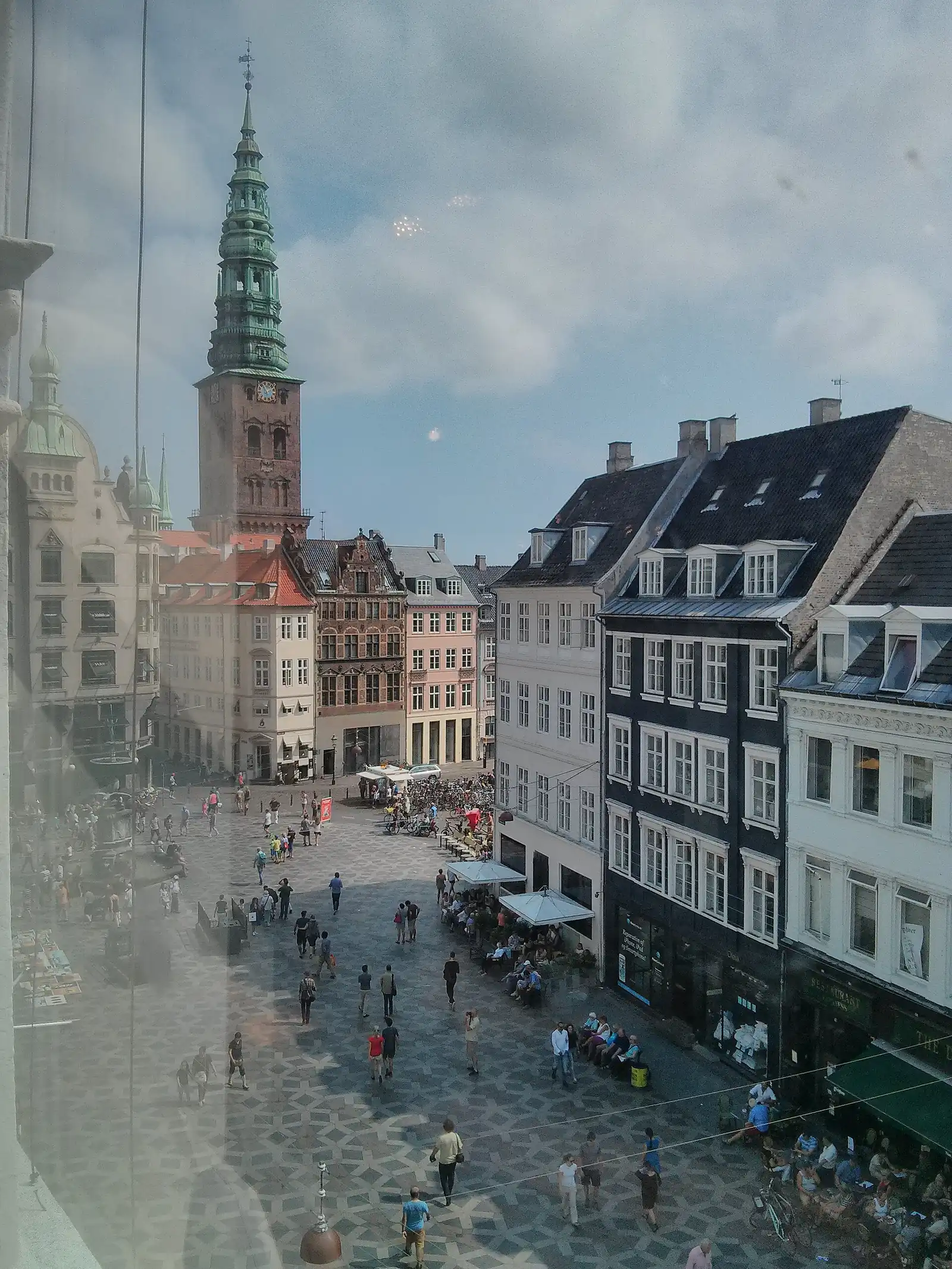 Shoppers on Amagertorv seen from an upper window of Illums Bolighus, with the green spire of Nikolaj behind