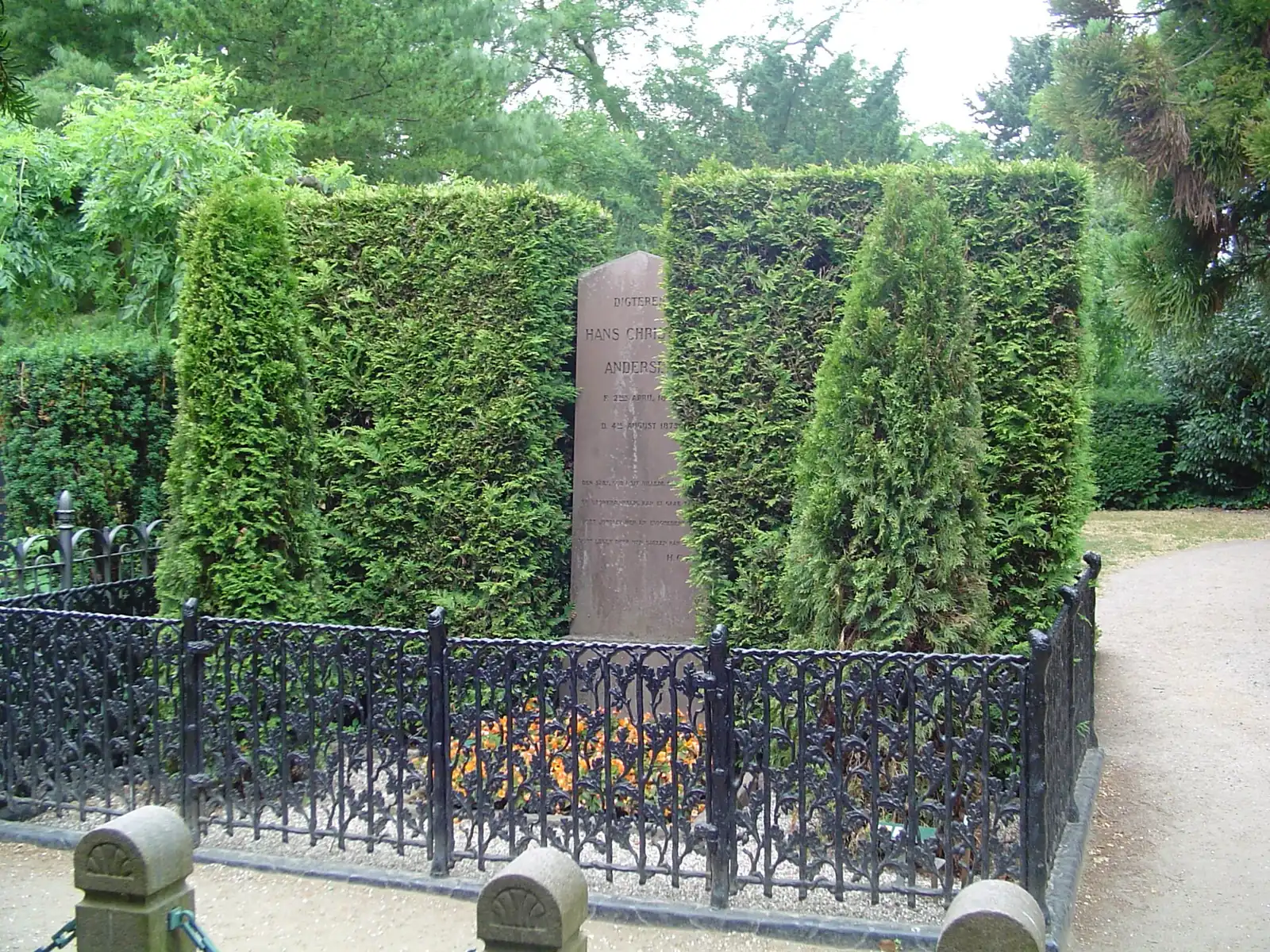 Hans Christian Andersen's grave stone behind iron railings in Assistens Cemetery