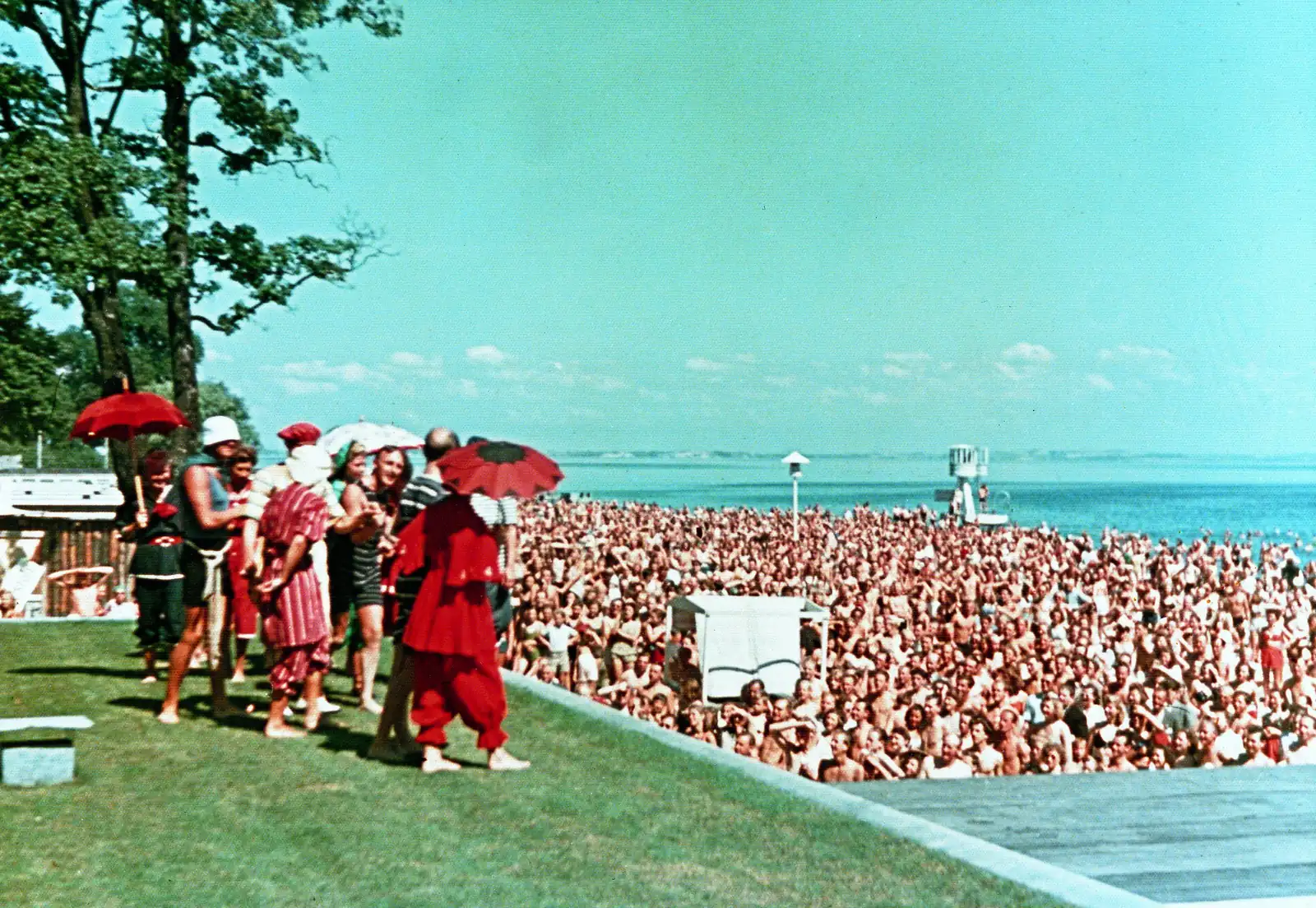 A huge crowd on Bellevue beach in the summer of 1944, watching costumed performers on the lawn
