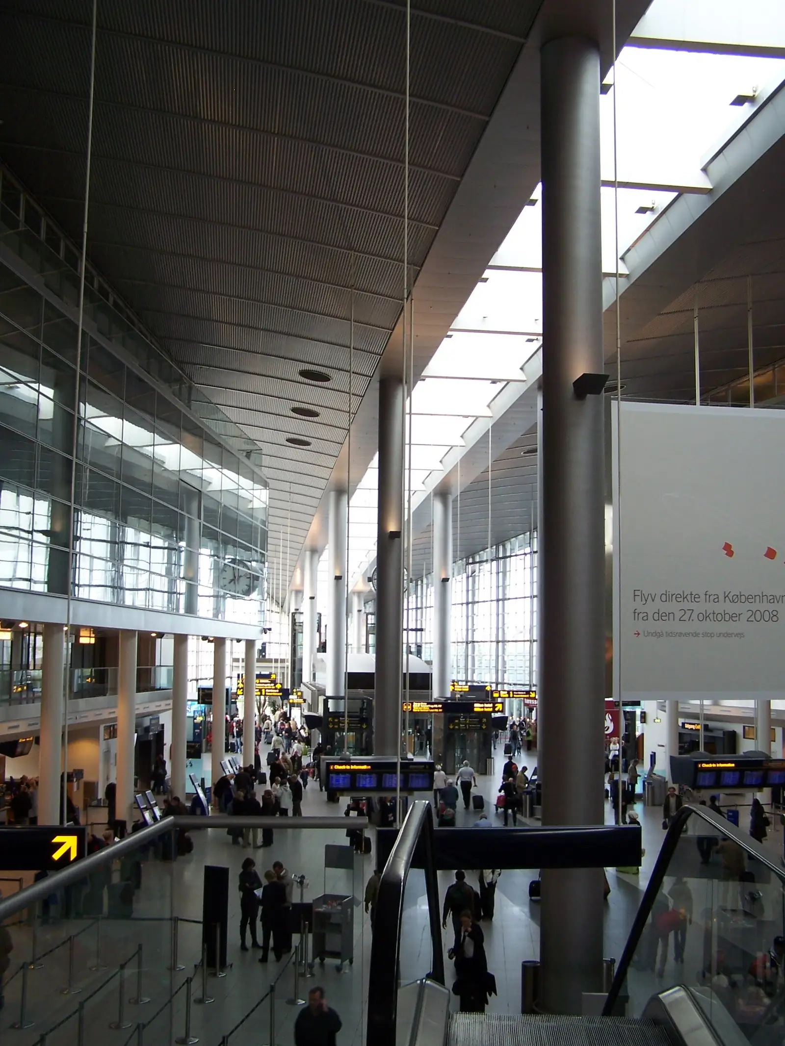 The check-in hall of Terminal 3 at Copenhagen Airport, with its curved ribbed ceiling, tall columns and departure boards