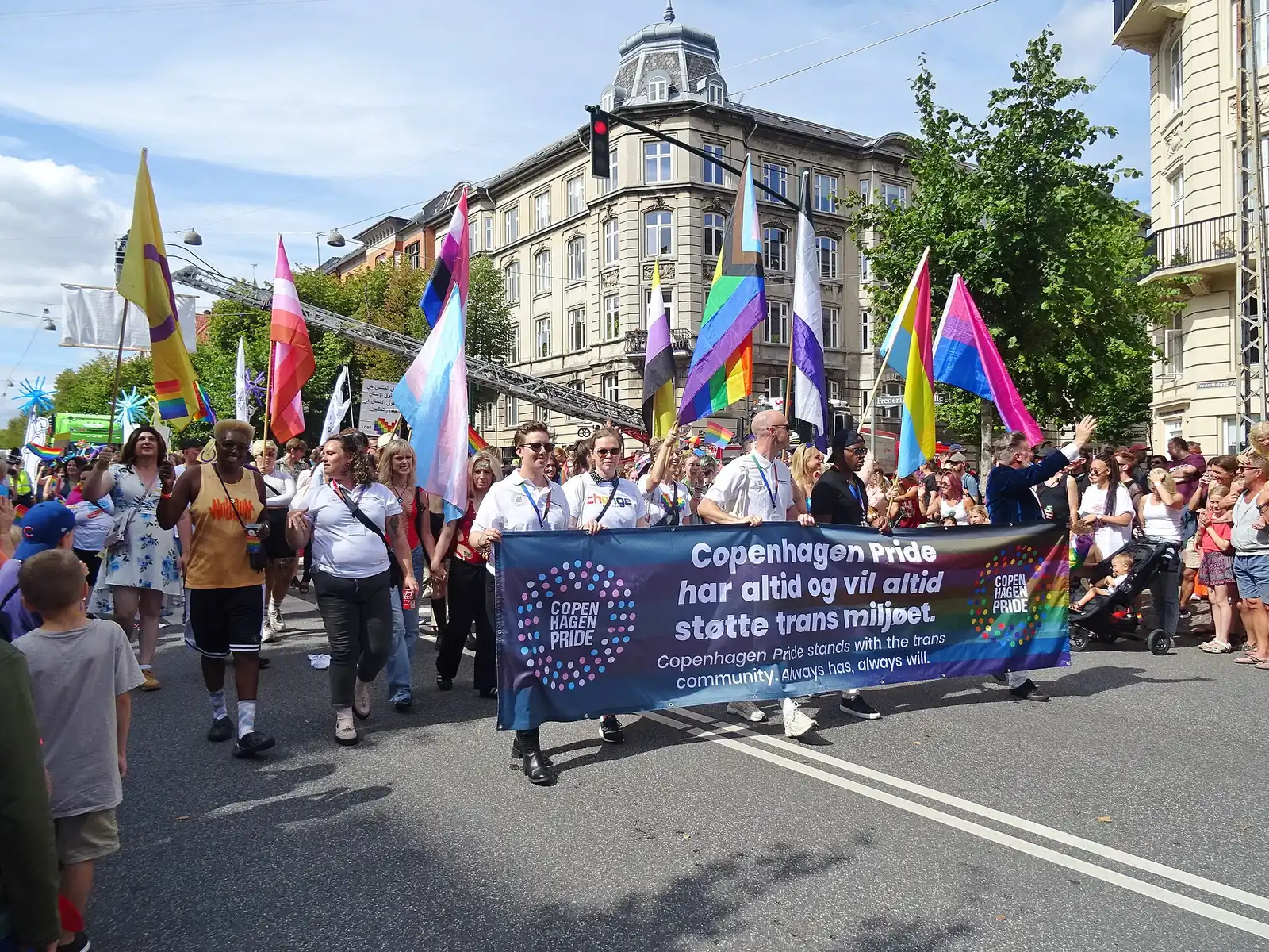 The Copenhagen Pride banner carried at the front of the parade on Frederiksberg Alle with Pride flags behind