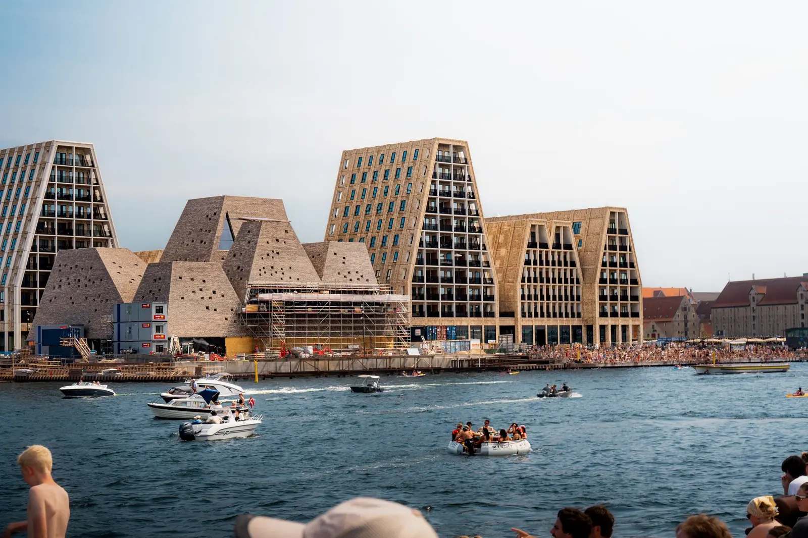 Swimmers, small boats and new waterfront buildings on Copenhagen's inner harbour on a warm afternoon