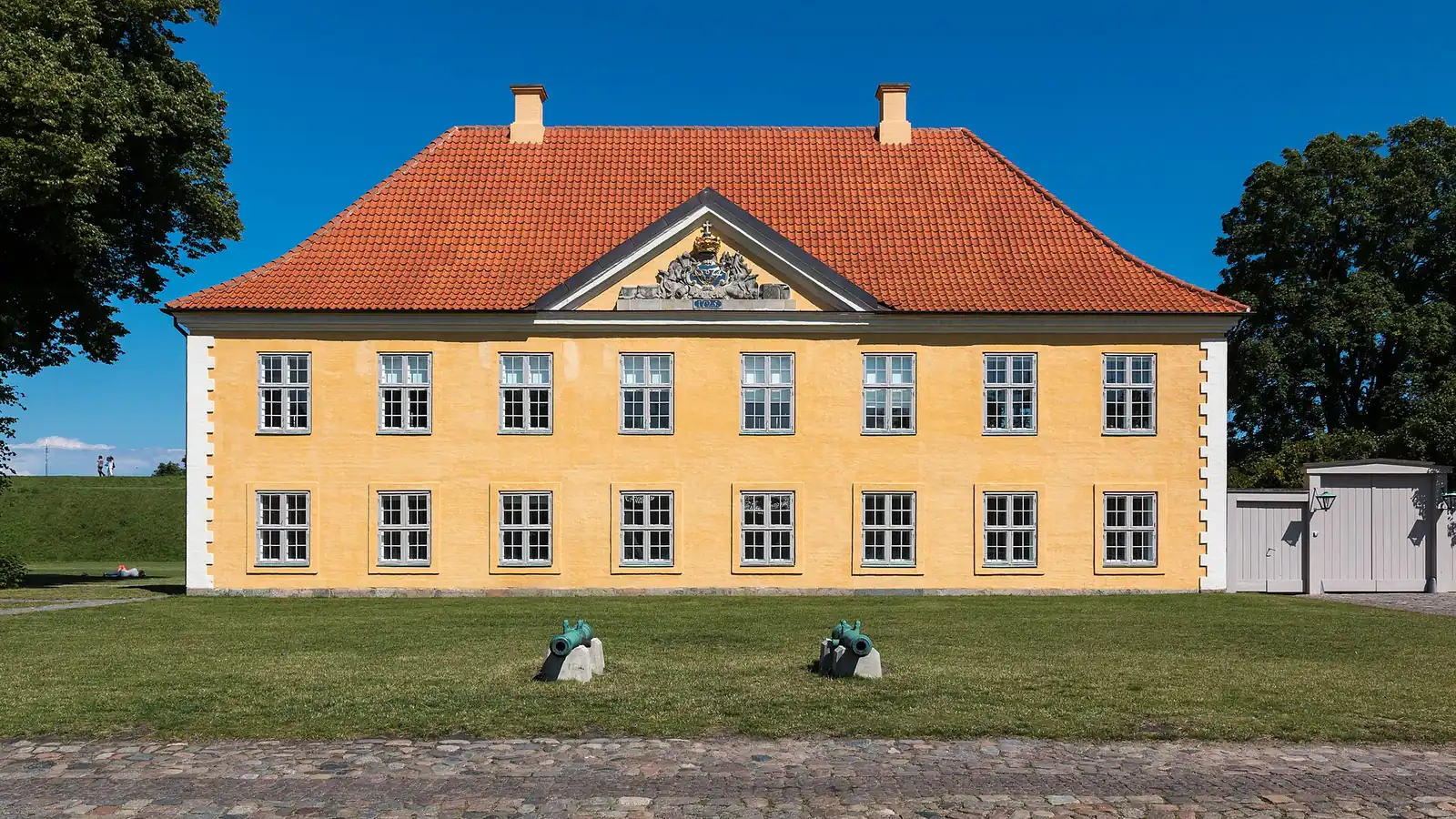 The yellow Commander's House at Kastellet, with two old cannon on the lawn in front