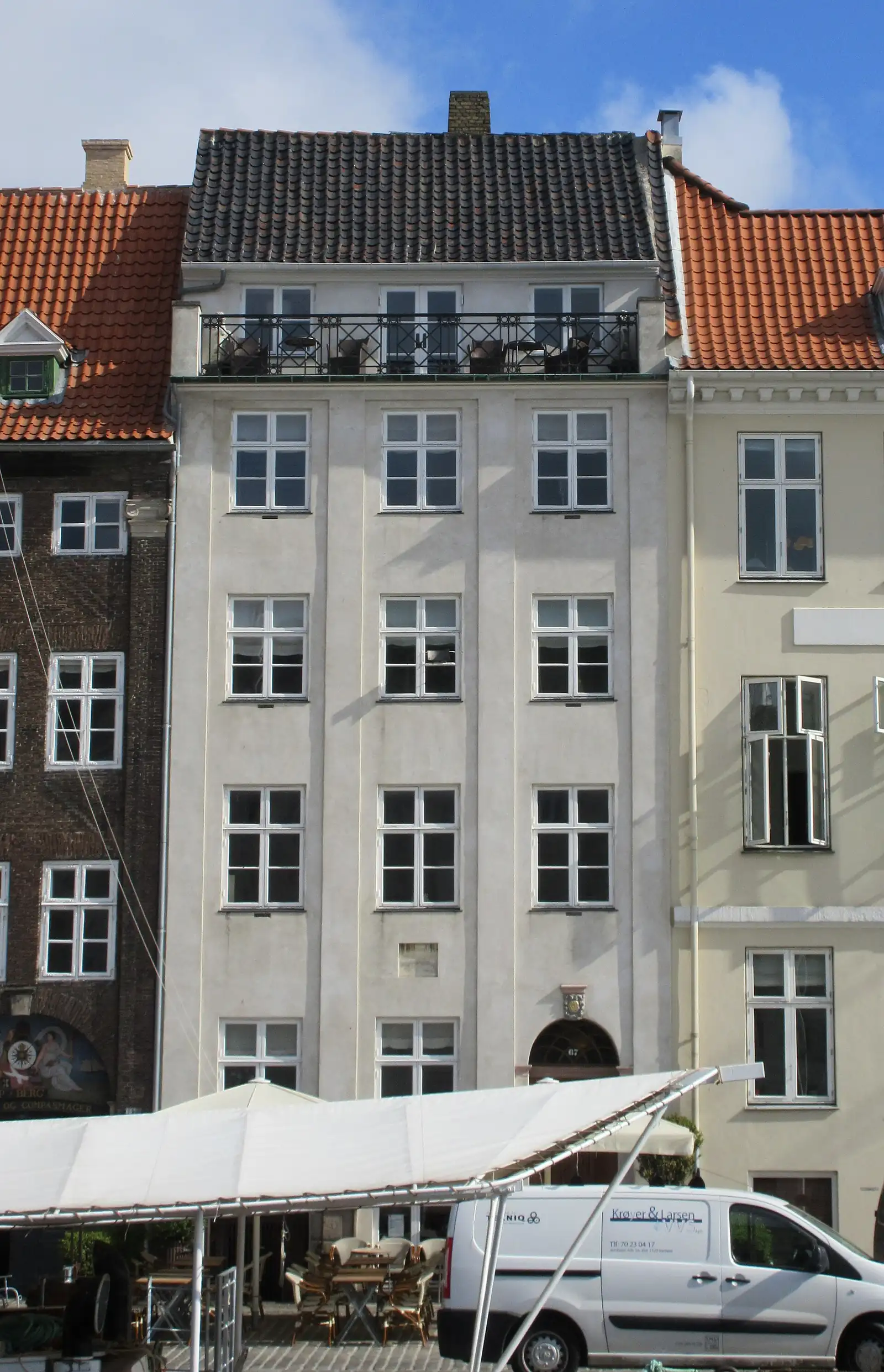 The white townhouse at Nyhavn 67 between its neighbours on the canal