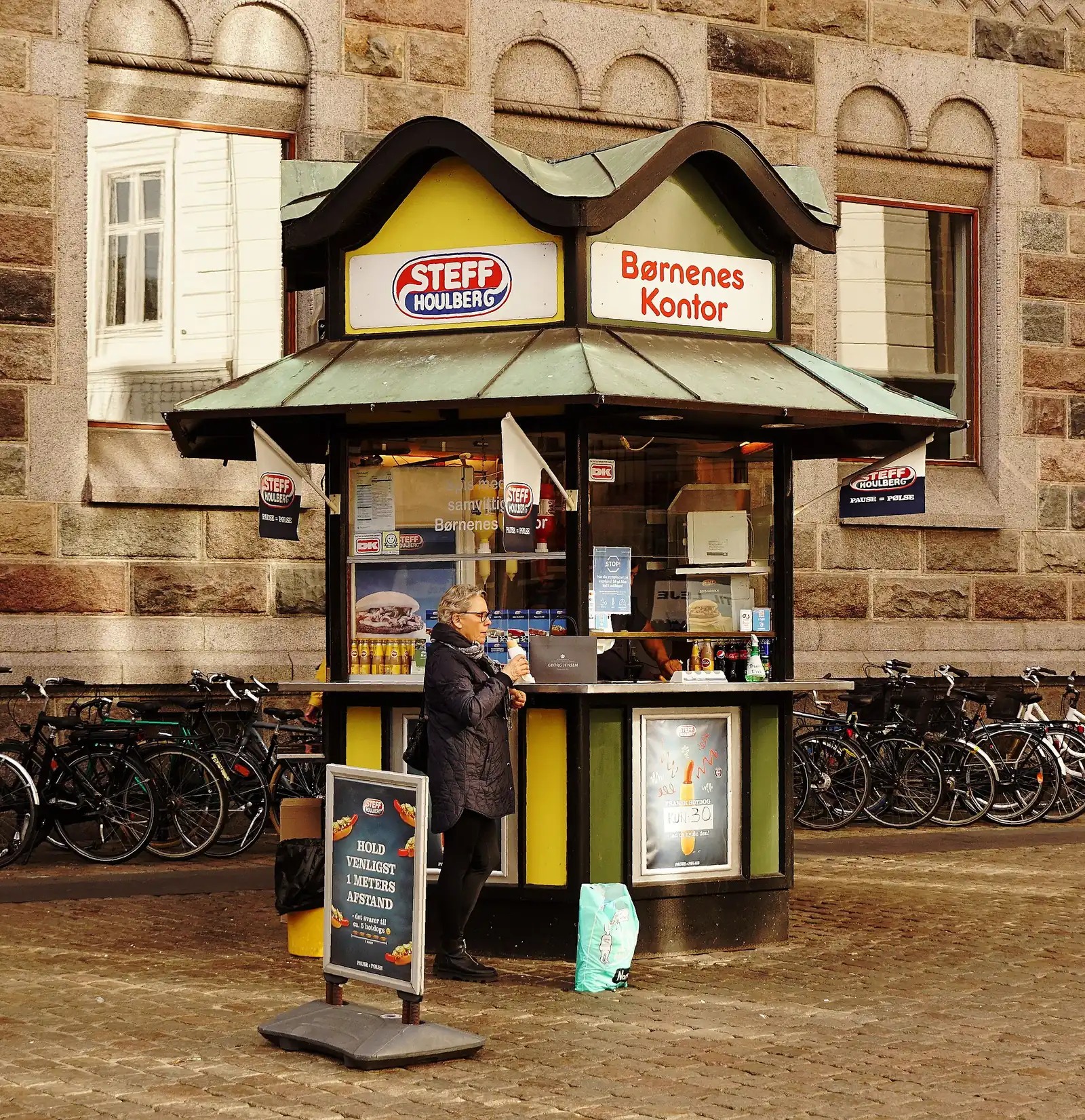 A green and yellow Steff Houlberg hot dog kiosk run for the Bornenes Kontor children's charity
