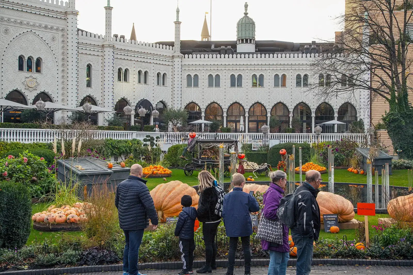 Visitors looking at pumpkin displays in Tivoli during the Halloween season, with the Nimb building behind